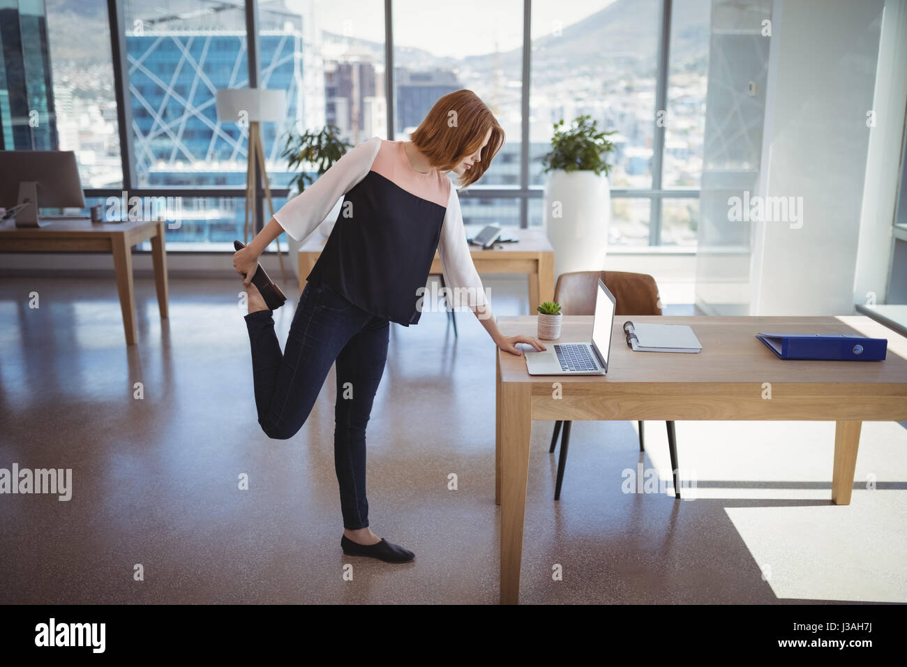 Esecutivo attento utilizzando computer portatile mentre si esercita in office Foto Stock