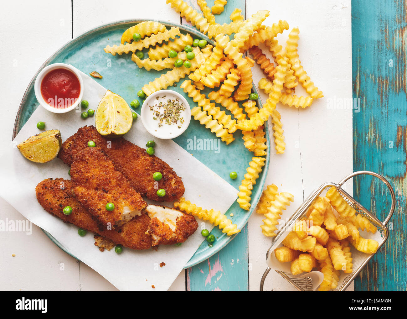 Pesce e patatine fritte con salse su tavola in legno rustico vista dall'alto uno spazio vuoto Foto Stock