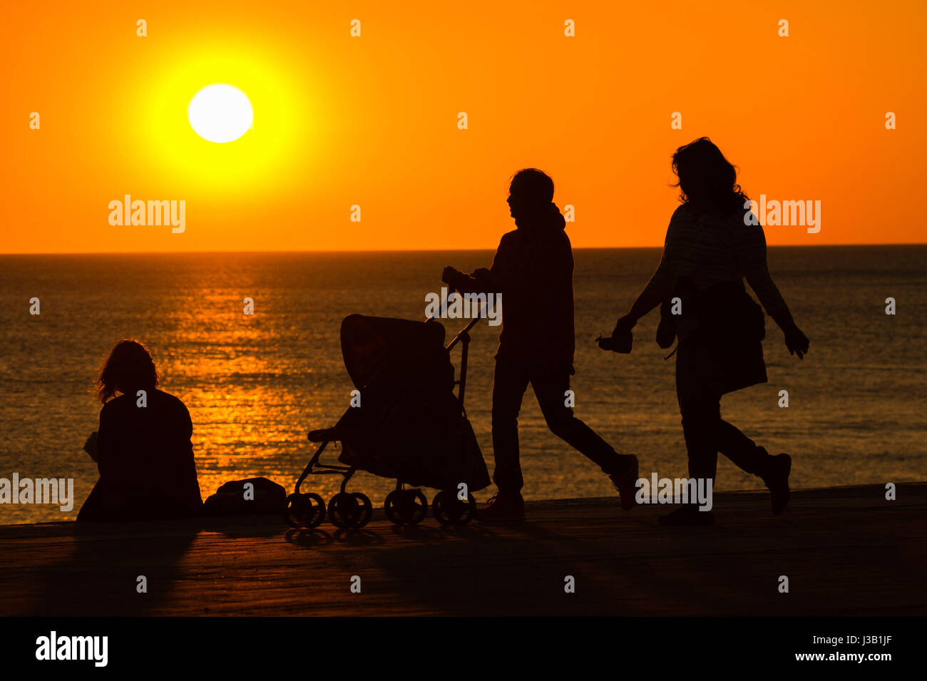 Aberystwyth Wales UK. Il 4 maggio, 2017. Regno Unito Meteo. Regno Unito: Meteo persone sul lungomare godendo di un glorioso Golden Sunset over il Cardigan Bay mare in Aberystwyth sulla West Wales coast UK Credito Foto : Keith Morris / Alamy Live news Foto Stock