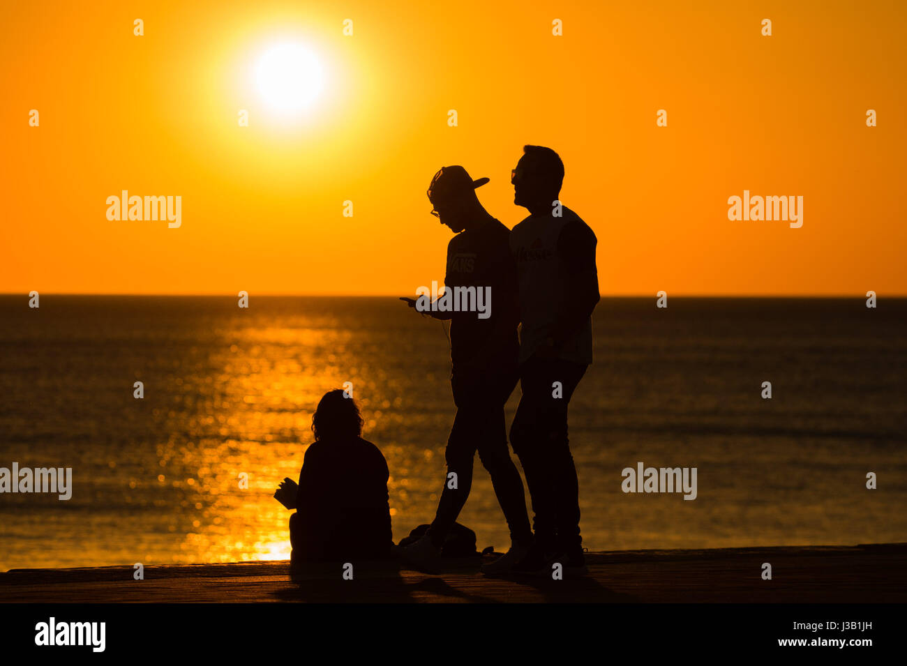 Aberystwyth Wales UK. Il 4 maggio, 2017. Regno Unito Meteo. Regno Unito: Meteo persone sul lungomare godendo di un glorioso Golden Sunset over il Cardigan Bay mare in Aberystwyth sulla West Wales coast UK Credito Foto : Keith Morris / Alamy Live news Foto Stock