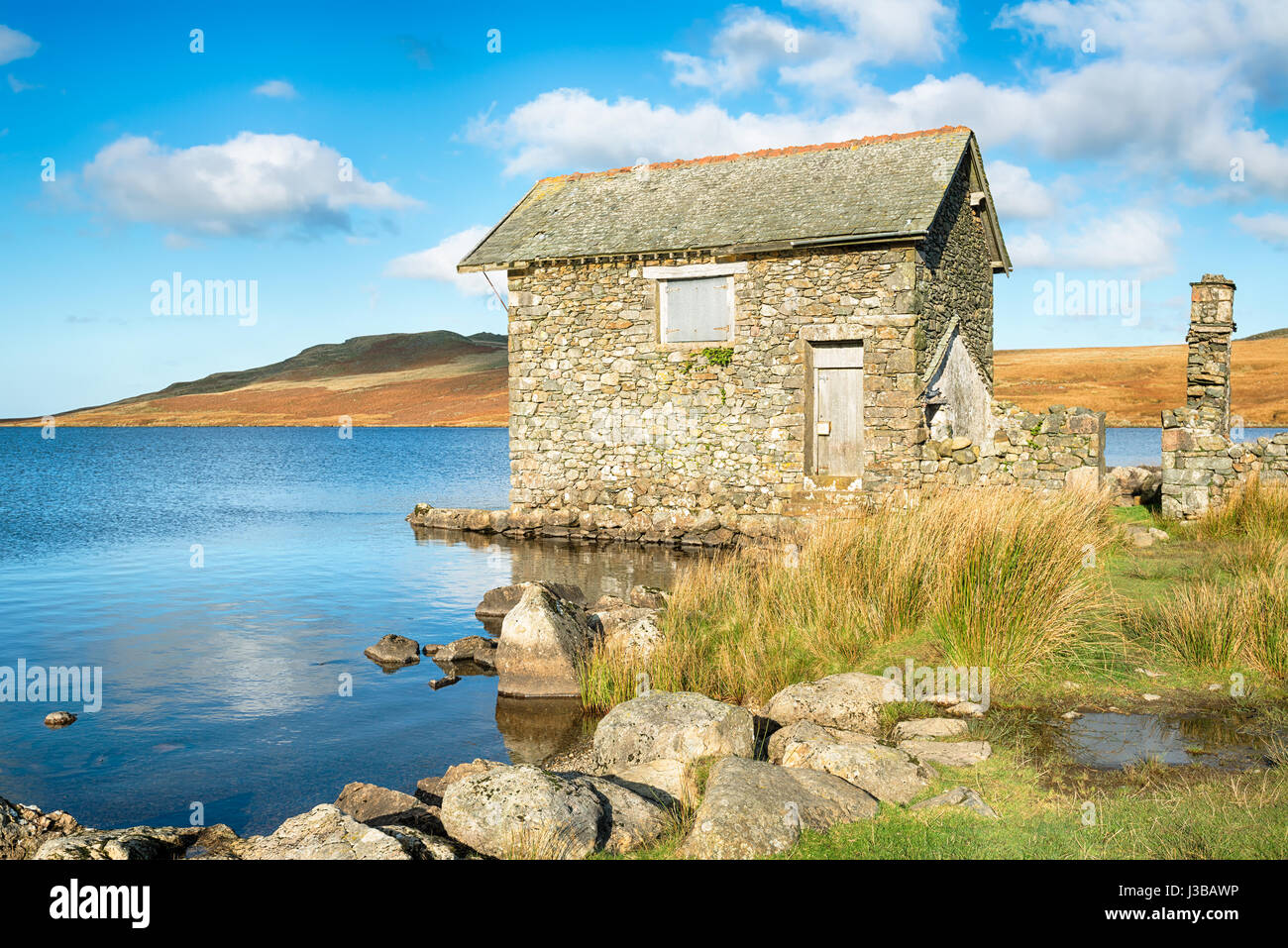 Le rovine di un antico in pietra al Boathouse Devoke acqua nel Parco nazionale del Lake District in Cumbria Foto Stock