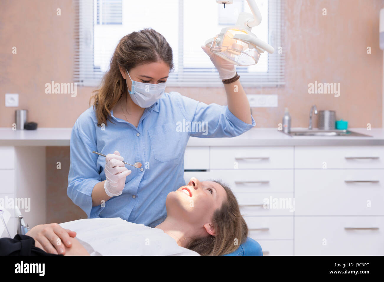 Dentista donna esame paziente Foto Stock