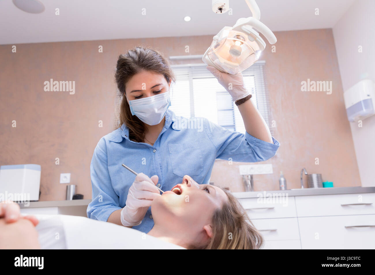 Dentista donna esame paziente Foto Stock