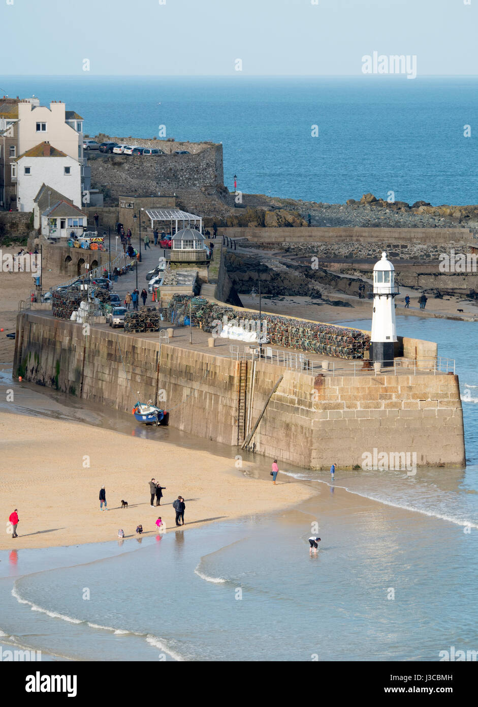 St Ives Cornish cittadina balneare, Sun cattura Smeatons Pier e Harbour Beach nel febbraio vicino a bassa marea, Cornwall Inghilterra. Foto Stock
