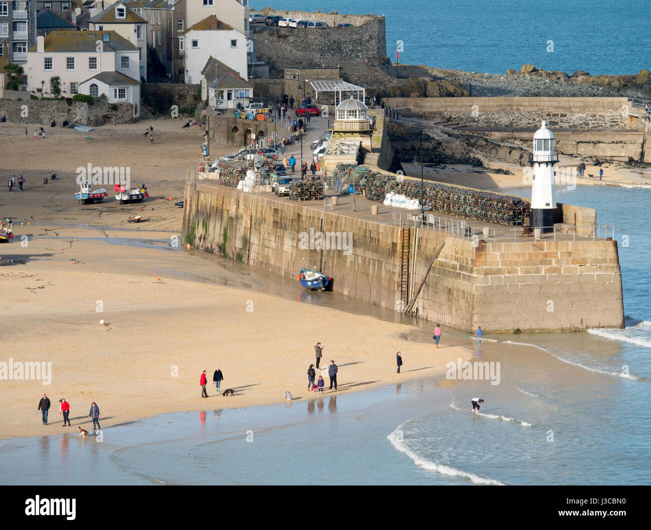St Ives Cornish cittadina balneare, Sun cattura Smeatons Pier e Harbour Beach nel febbraio vicino a bassa marea, Cornwall Inghilterra. Foto Stock