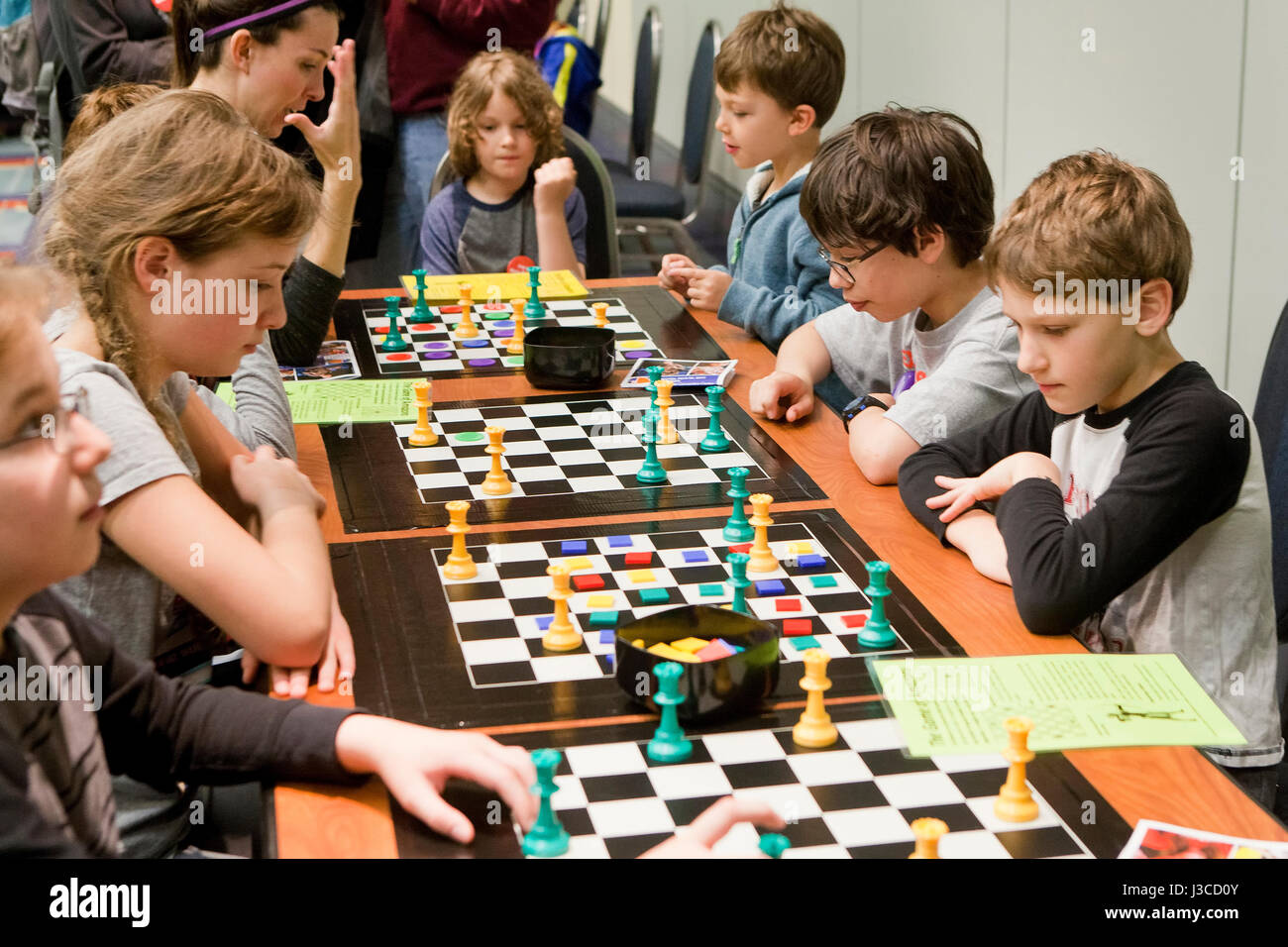 Caucasica scuola americana i bambini giocando il gioco delle Amazzoni board game - USA Foto Stock