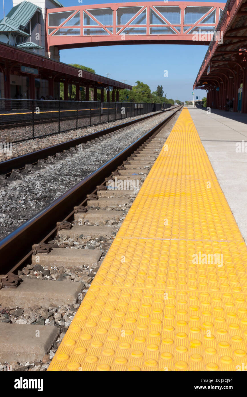Binari del treno e della piattaforma in corrispondenza di una stazione ferroviaria in Florida. Foto Stock