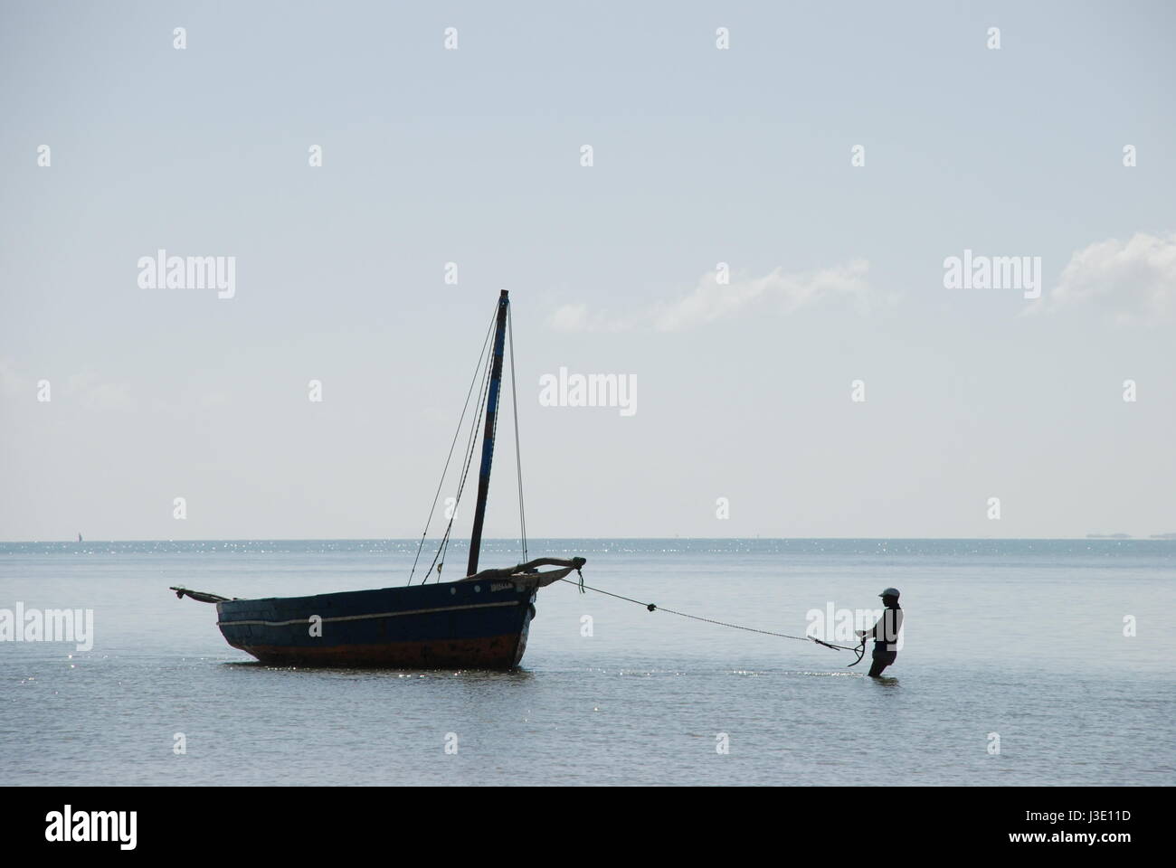 Pescatore con il suo tradizionale dhow barca da pesca a Vilanculos, Inhambane provincia, Mozambico, Africa. Foto Stock