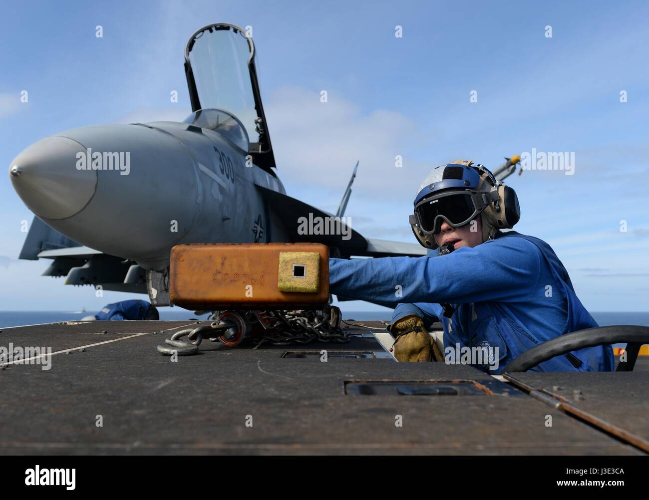 Un soldato nordamericano si muove un USN F/A-18E Super Hornet jet da combattimento sul ponte di volo a bordo della USN Nimitz-class portaerei USS Nimitz Aprile 7, 2017 nell'Oceano Pacifico. (Foto di MCSS Ian Kinkead /US Navy via Planetpix) Foto Stock