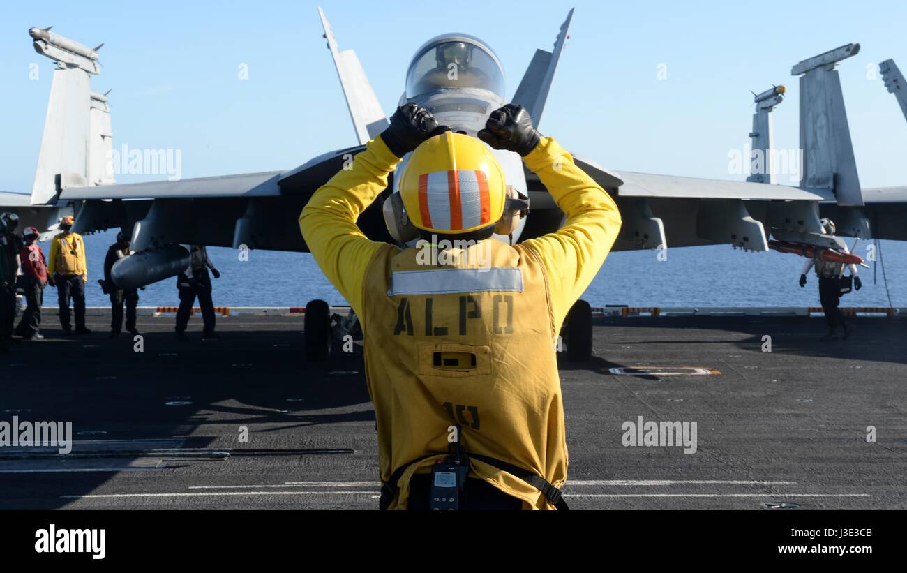U.S. marinai dirigere una F18 Fighter Aircraft lancio dal ponte di volo a bordo della USN Nimitz-class portaerei USS Nimitz Aprile 7, 2017 nell'Oceano Pacifico. (Foto di MCSS Ian Kinkead /US Navy via Planetpix) Foto Stock