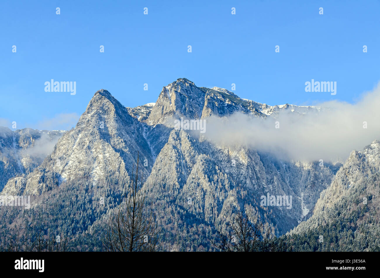 Carpazi, Bucegi con Caraiman Peak, nuvole, neve e nebbia invernale paesaggio Foto Stock