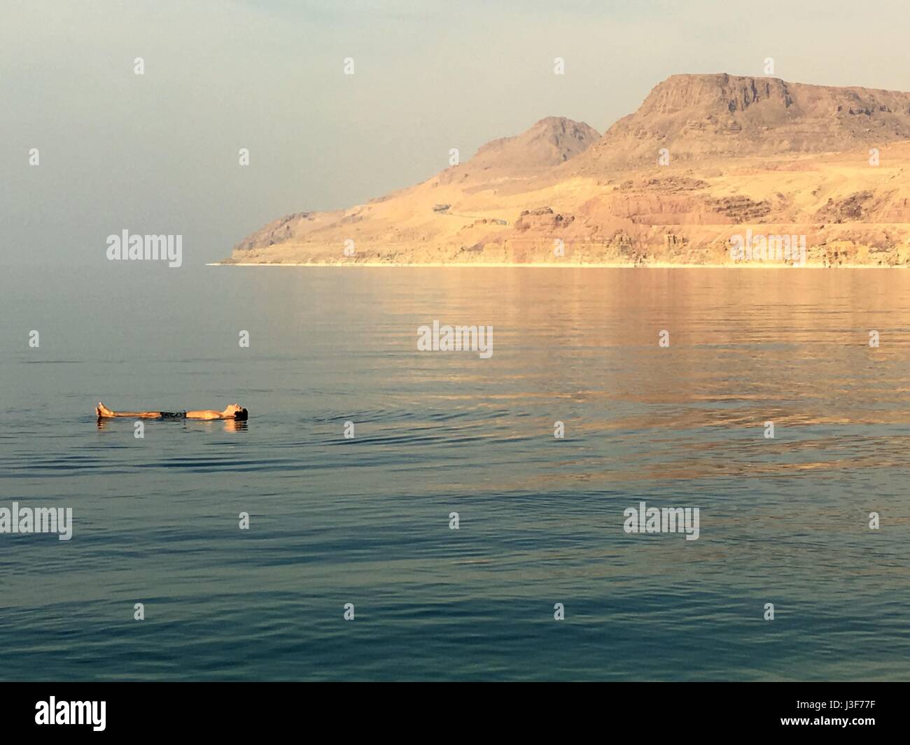 Floating presso il Mar Morto vicino a Wadi Mujib, Giordania, Medio Oriente. A Mujib chalet, sole, acqua salata Foto Stock