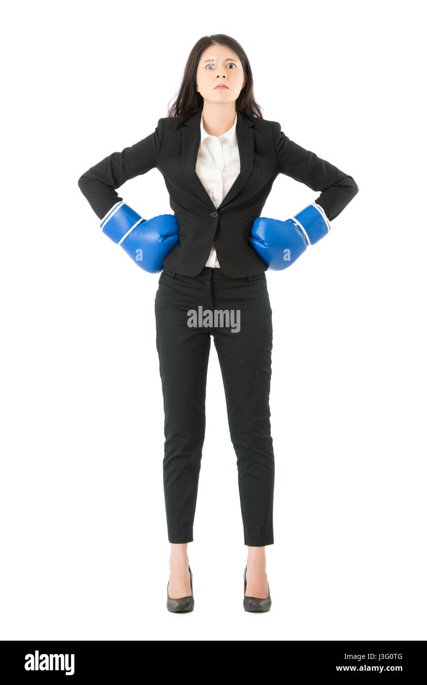 Imprenditrice intimidatorio permanente indossando guanti da boxe pronto per la concorrenza. Strong business donna boss concetto esecutivo. Atteggiamento fiducioso Foto Stock