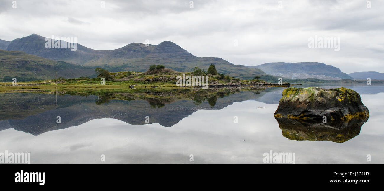 Le montagne di Wester Ross nel west Highlands della Scozia sono riflesse nelle calme acque del mare di Loch Torridon. Foto Stock