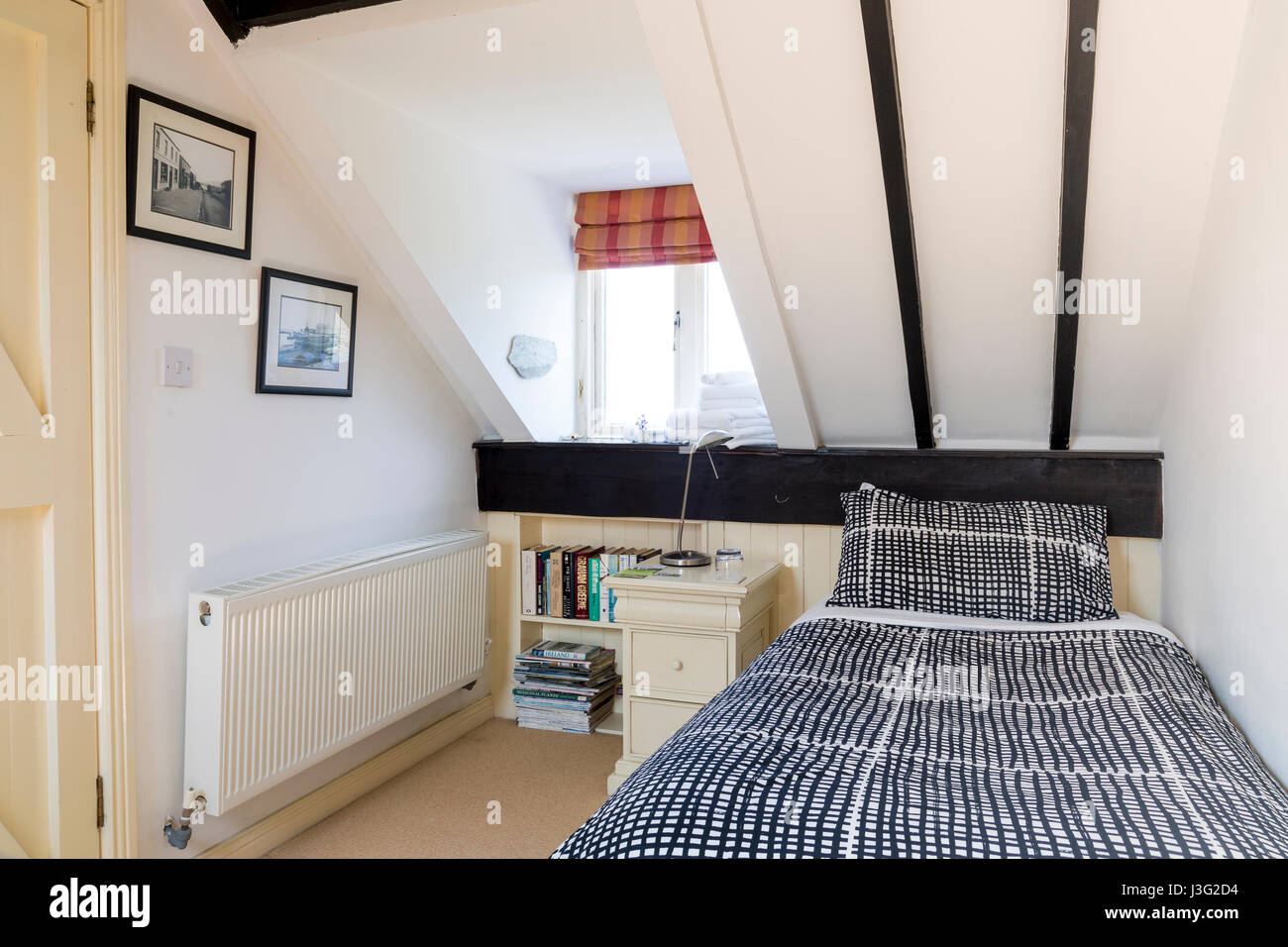 Moderno ed elegante camera da letto mansarda, soffitto pendente Foto Stock