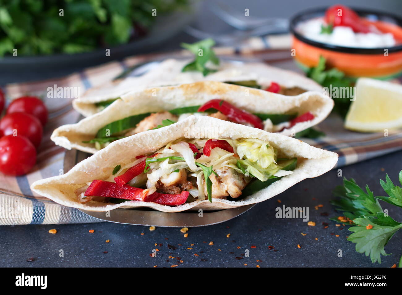 Pita riempito con petto di pollo alla brace, insalate fresche, cetriolo, paprica dolce, cipolla e salsa di yogurt su un astratto bianco sullo sfondo. Cucina casalinga. Foto Stock