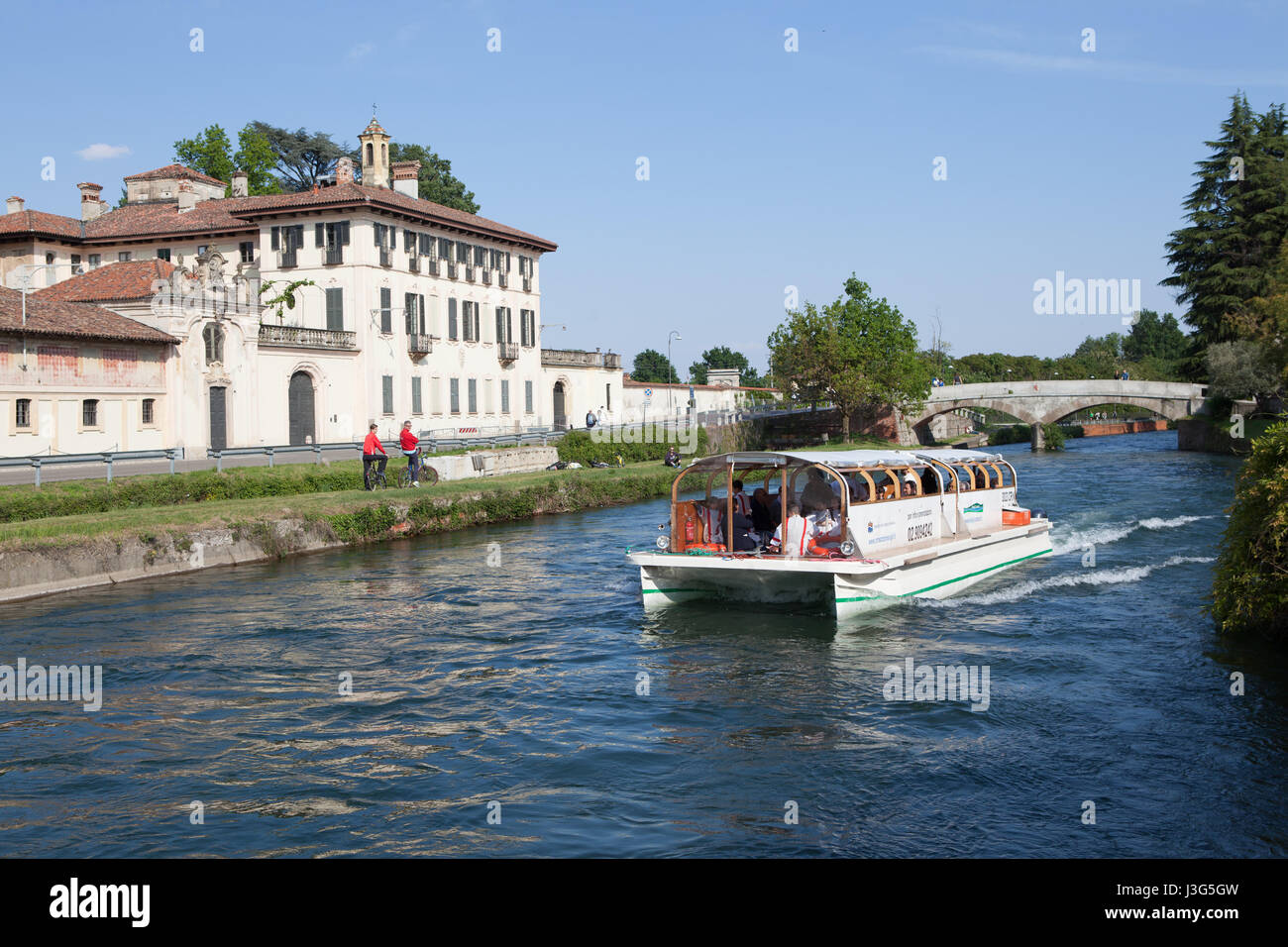 Un turista crociera in barca sul Naviglio Grande Fiume, in background Villa Visconti Maineri Castiglione, a poca distanza da Milano. Cassinetta di L Foto Stock