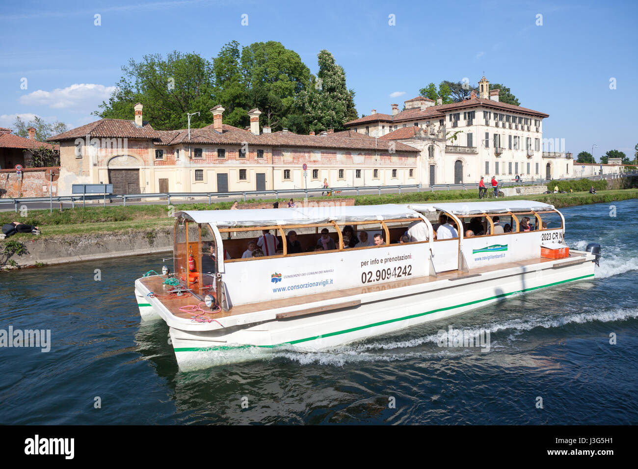 Un turista crociera in barca sul Naviglio Grande Fiume, in background Villa Visconti Maineri Castiglione, a poca distanza da Milano. Cassinetta di L Foto Stock