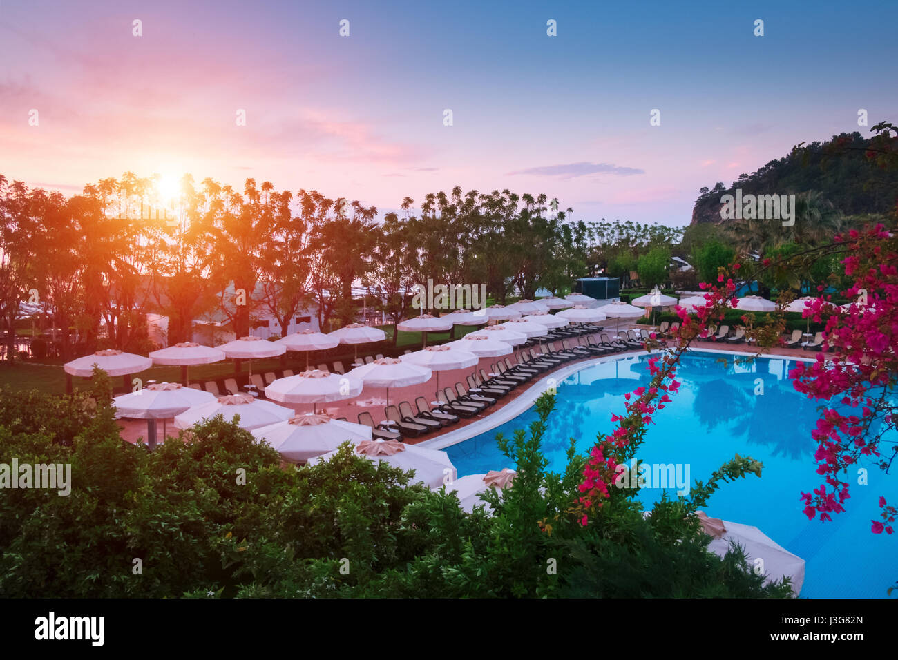 Piscina con ombrelloni e sdraio in mattina tempo. Scena meravigliosa vicino al mare mediterraneo Foto Stock