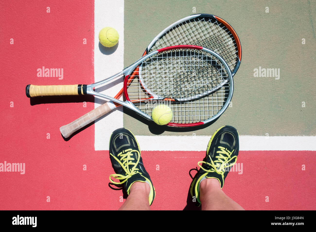 Concetto di tennis con due racchette, palle e giocatore gambe. Sfondo di sport Foto Stock