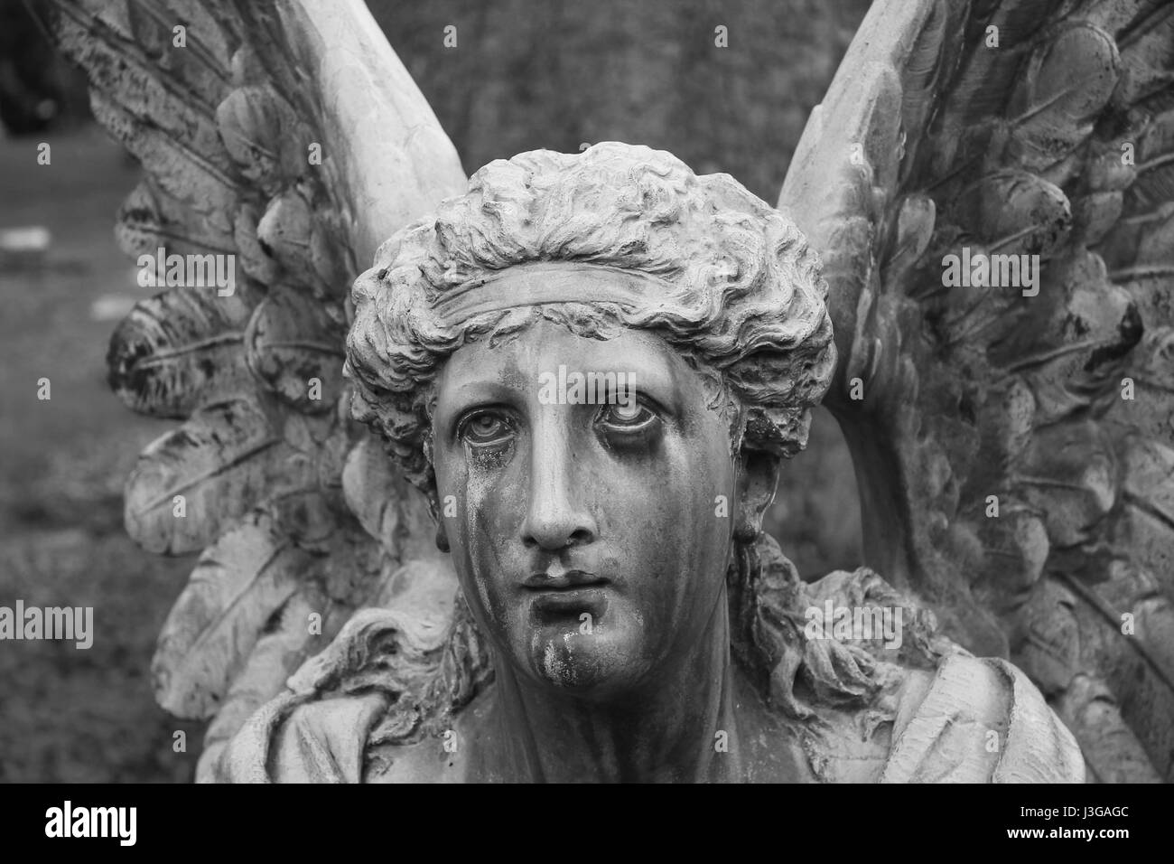 Weathered statua sembra versando lacrime oltre alla carica in Spring Grove cimitero di Cincinnati in Ohio. Foto Stock