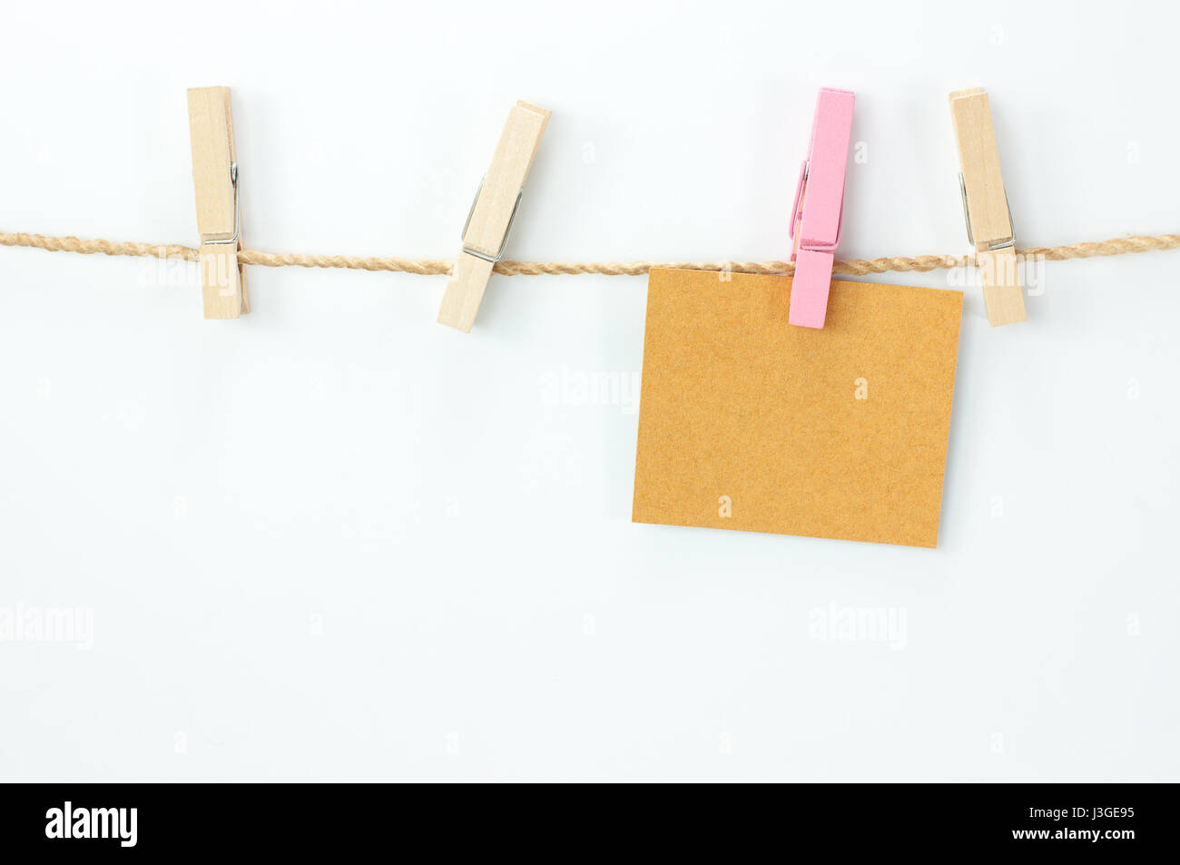 Avviso card, carta marrone e clip di legno su sfondo bianco Foto Stock