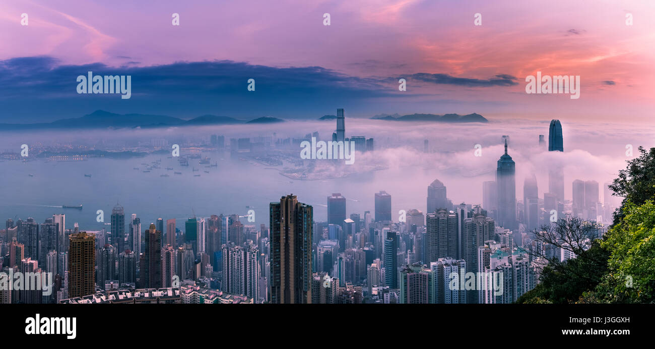 Misty città e il porto di Sunrise - Victoria Harbour di Hong Kong Foto Stock