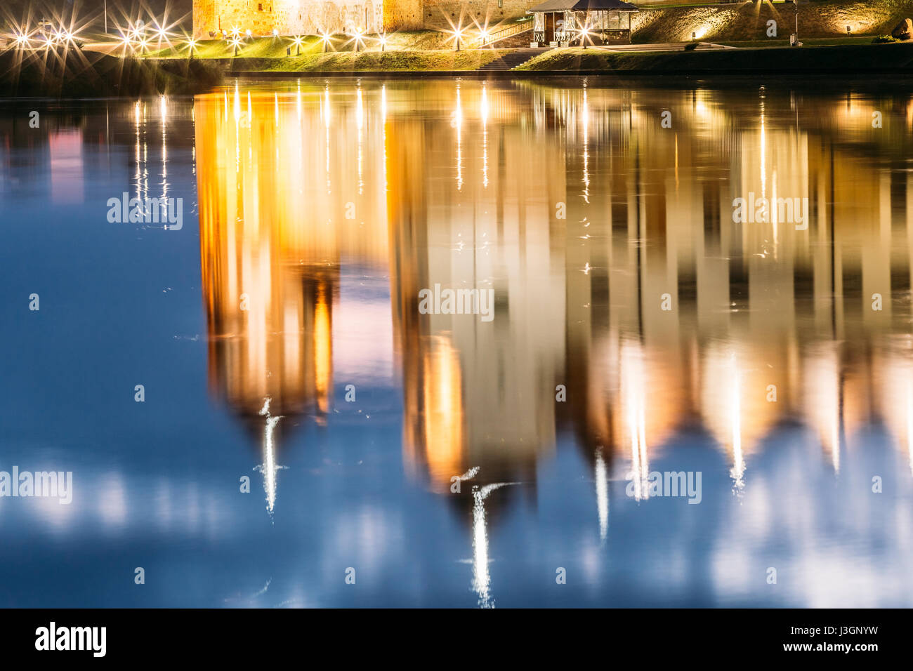 Mir, Bielorussia. Complesso del Castello di Mir In brillante illuminazione serale con candelette di riflessioni sul lago di acqua. Famoso punto di riferimento, antico monumento gotico di Feuda Foto Stock