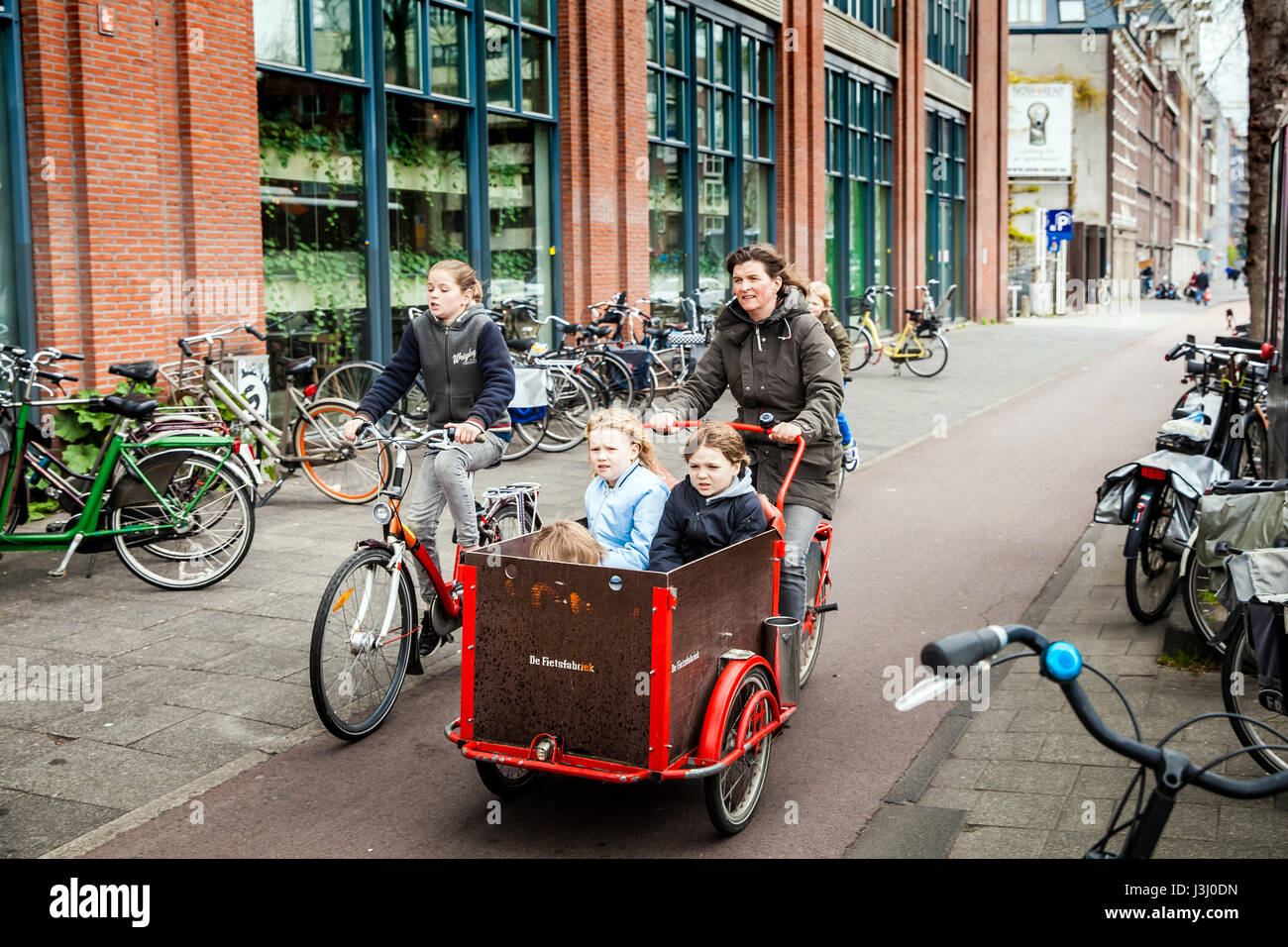 Madre di tre figli sulla bicicletta in Amsterdam, Paesi Bassi Foto Stock