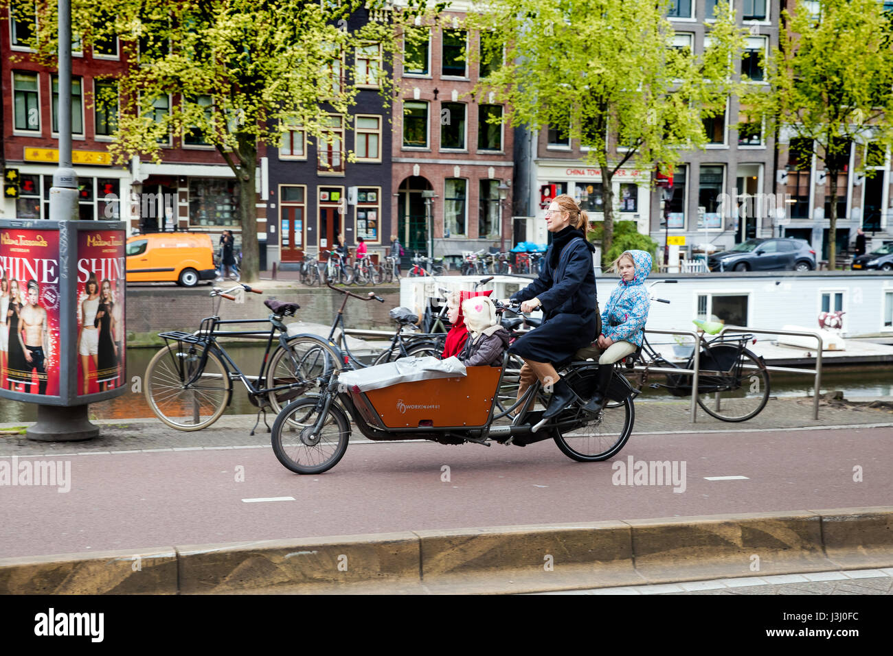 Madre di tre figli sulla bicicletta in Amsterdam, Paesi Bassi Foto Stock