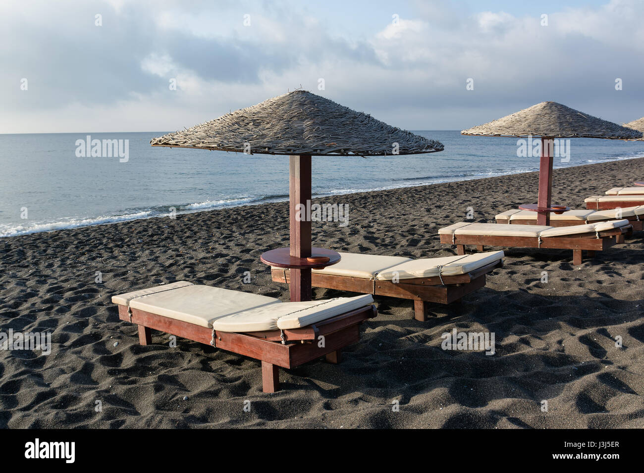 Lettini e ombrelloni a Perissa beach - Santorini Island, Grecia Foto stock  - Alamy