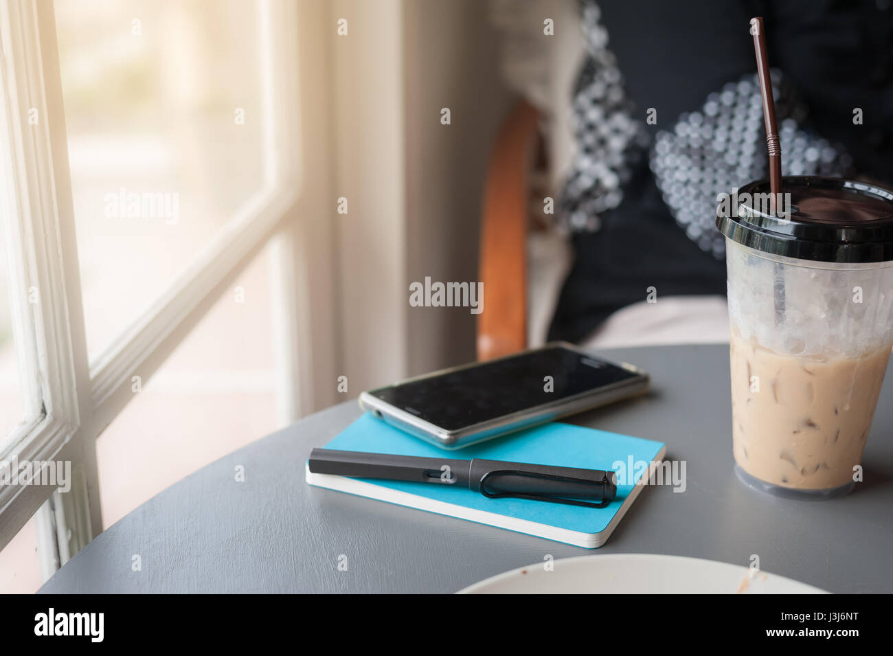 Lo stile di vita del freelancer. pen, notebook, smartphone e la tazza di caffè sul tavolo in coffee shop. lavorare da casa e esternalizzare il concetto di lavoratore Foto Stock