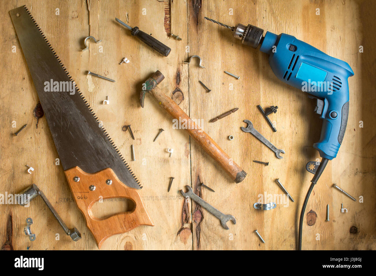 Il martello e le viti su sfondo di legno Foto Stock