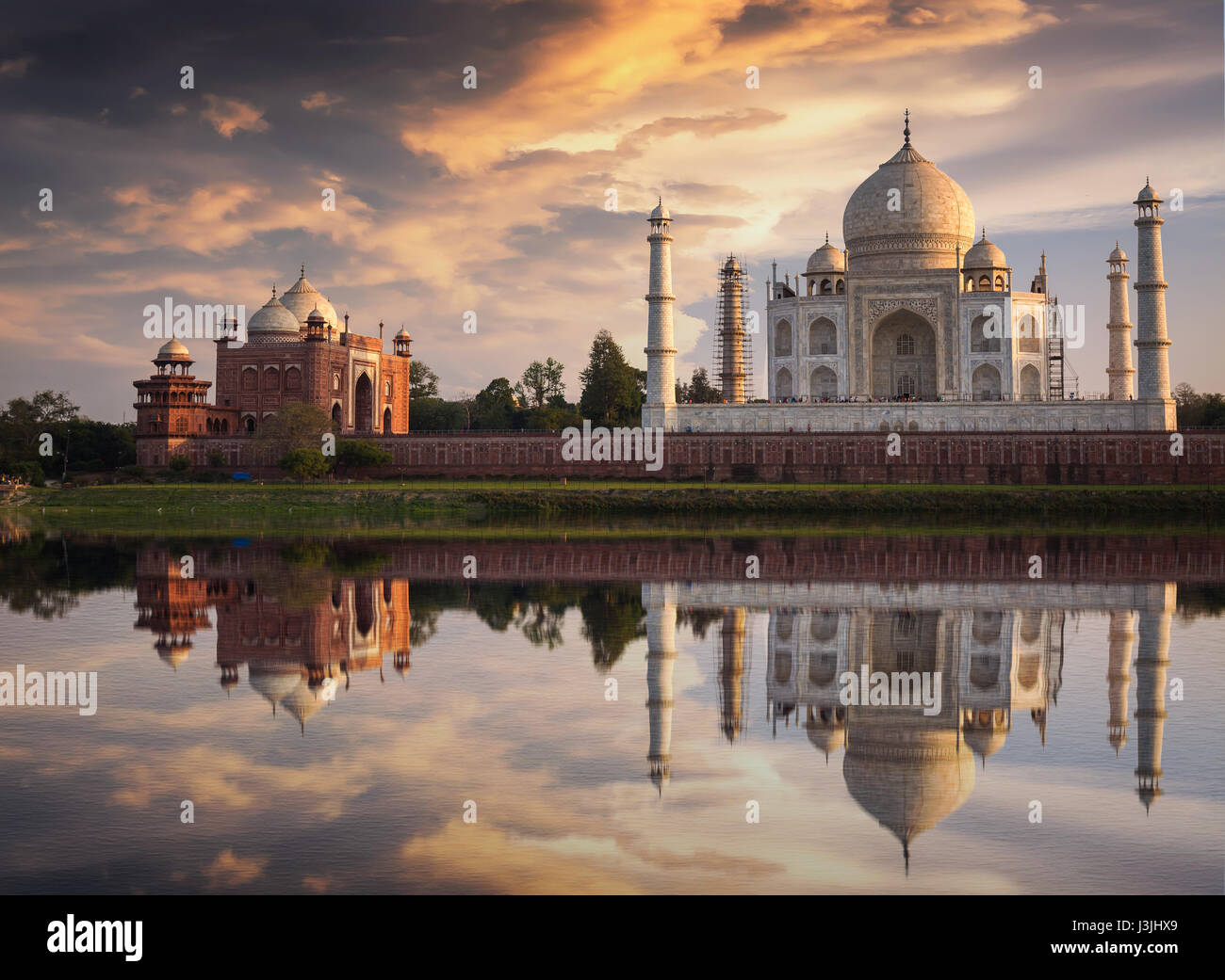 Taj Mahal vista al tramonto dalle rive del fiume Yamuna. Taj Mahal è un marmo bianco mausoleo designato come sito del patrimonio mondiale dell'UNESCO Foto Stock