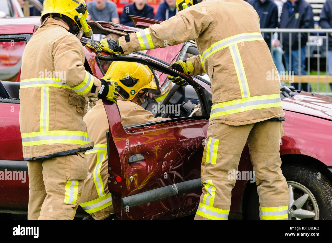 Firecrew dall Irlanda del Nord il fuoco e il servizio di soccorso di dimostrare come usare idraulico attrezzature di taglio per liberare un driver intrappolato da una vettura dopo un Foto Stock