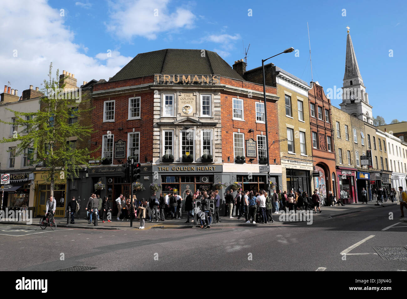 La folla di persone in piedi in strada in primavera a bere birra al di fuori di Truman's pub birreria il cuore d'oro in Spitalfields East London KATHY DEWITT Foto Stock