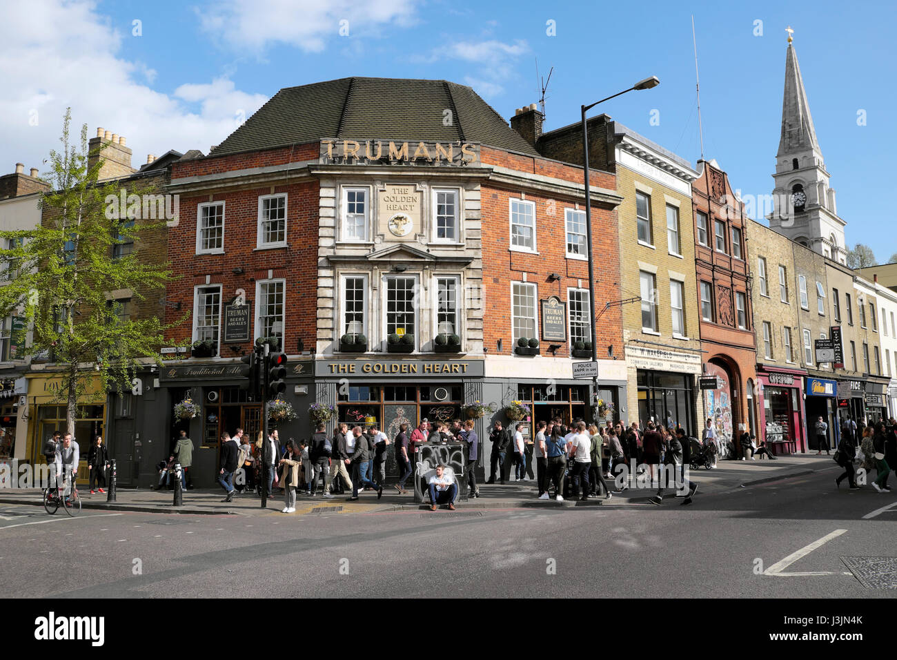 Persone fuori dal pub Truman's il cuore d'oro all'angolo tra la trafficata Commercial St e la strada commerciale di Hanbury Street East London E1 KATHY DEWITT Foto Stock