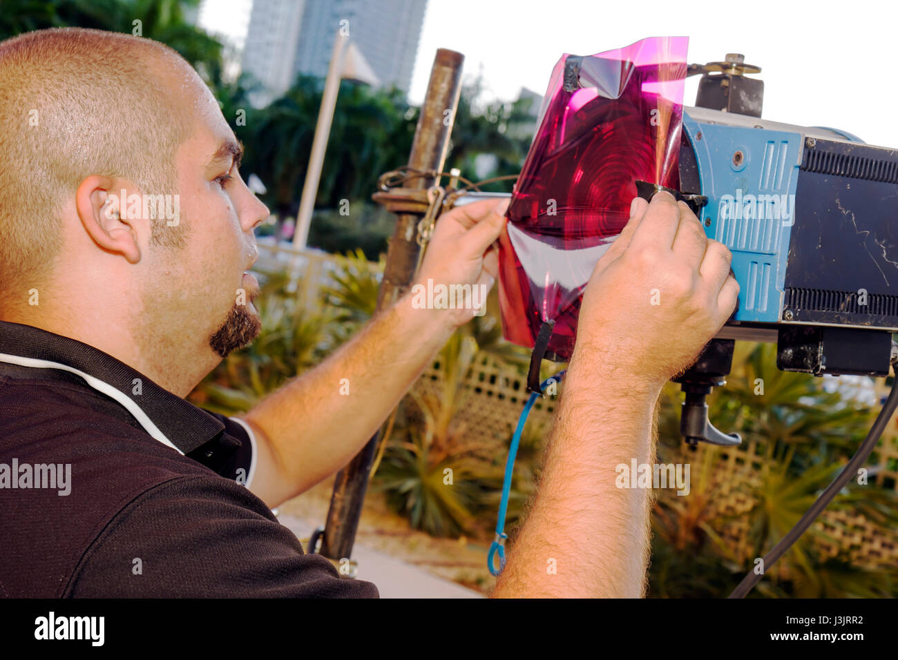 Miami Florida,tecnico illuminazione,uomo ispanico maschio,proiettore,gelatina colore,FL081019058 Foto Stock