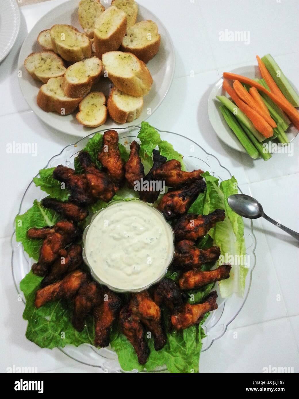 Tamburi di pollo, pane all'aglio, salsa di aglio e veggie bastoni. Foto Stock