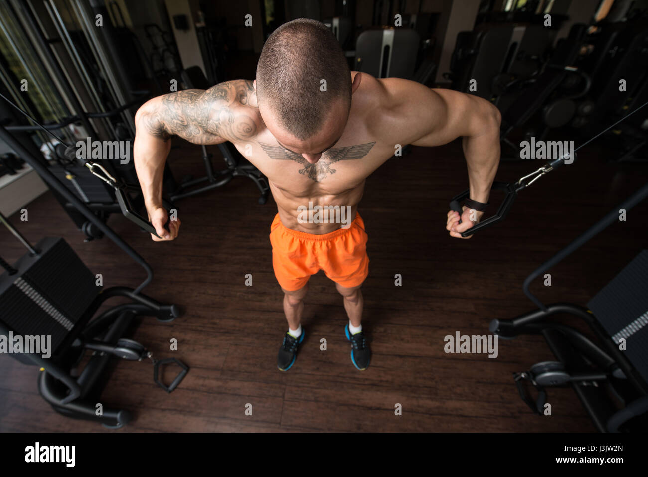 Atleta sta lavorando sul suo petto con cavo crossover in palestra Foto Stock