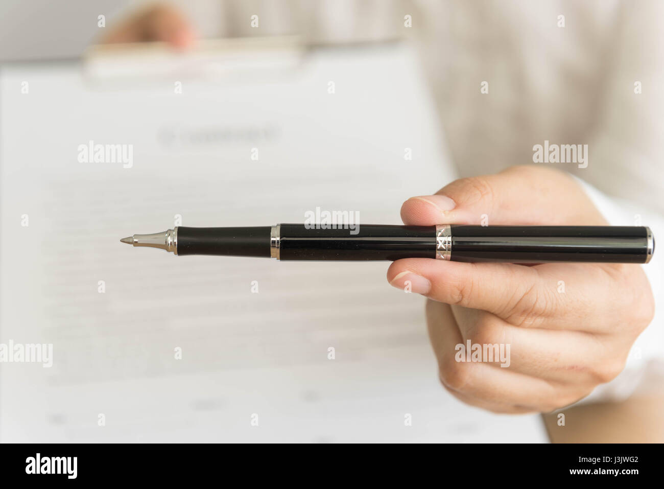 Imprenditore di consegnare un contratto collegato per la firma e la penna in mano. il fuoco selettivo. Foto Stock