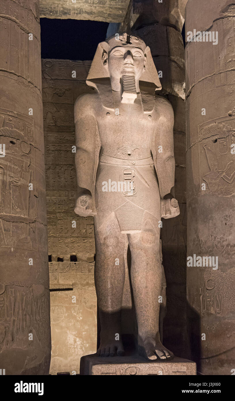 Antica statua di Ramses II al tempio di Luxor illuminato di notte Foto Stock