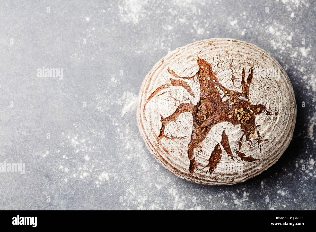 Pane di segale, grano intero su un livello di grigio ardesia sfondo. Vista dall'alto. Copia dello spazio. Foto Stock