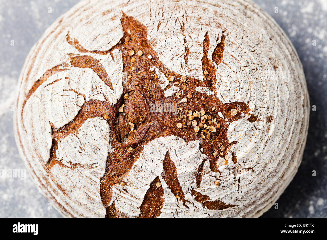 Pane di segale, grano intero su un livello di grigio ardesia sfondo. Vista dall'alto. Foto Stock