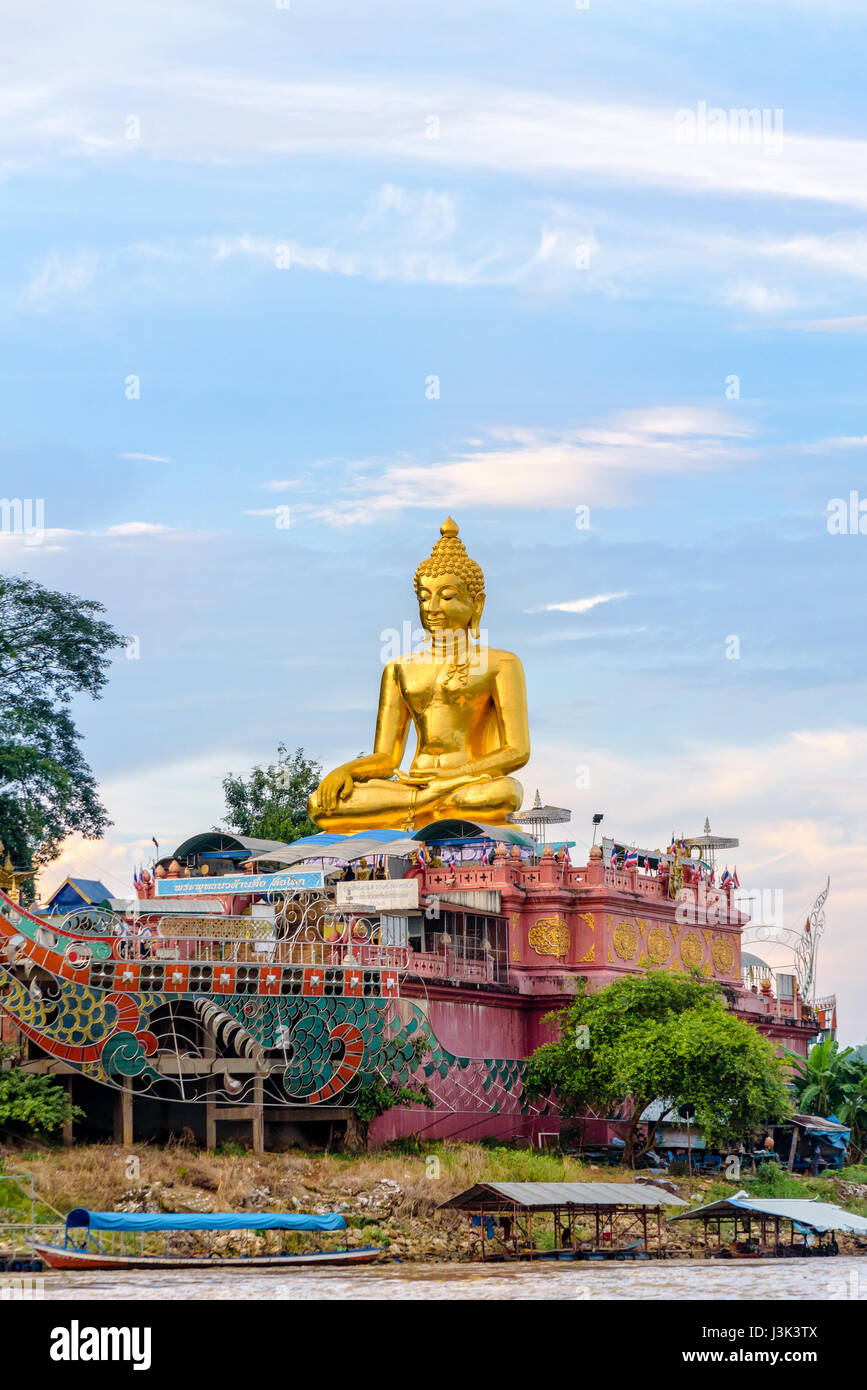 Beautiful golden statua del Buddha di Buddha Phra Nawa Lan Mar sulle rive del fiume Mekong al Golden Triangle Park (Sob Ruak) durante la serata in C Foto Stock
