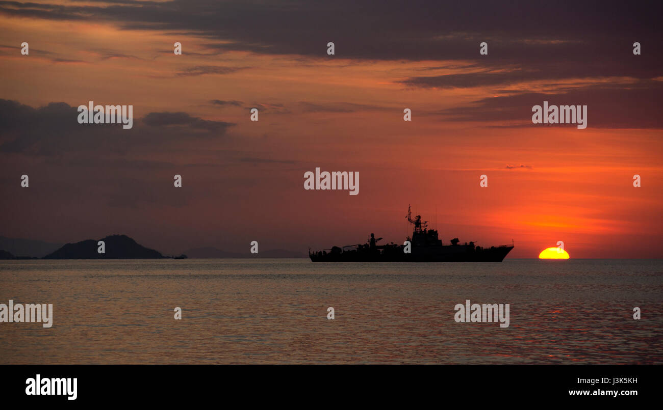 Silhouette di grande nave sull'oceano al tramonto con arancione tramonto sullo sfondo combinato con un cielo nuvoloso, Labuan Bajo, Bajawa. Foto Stock