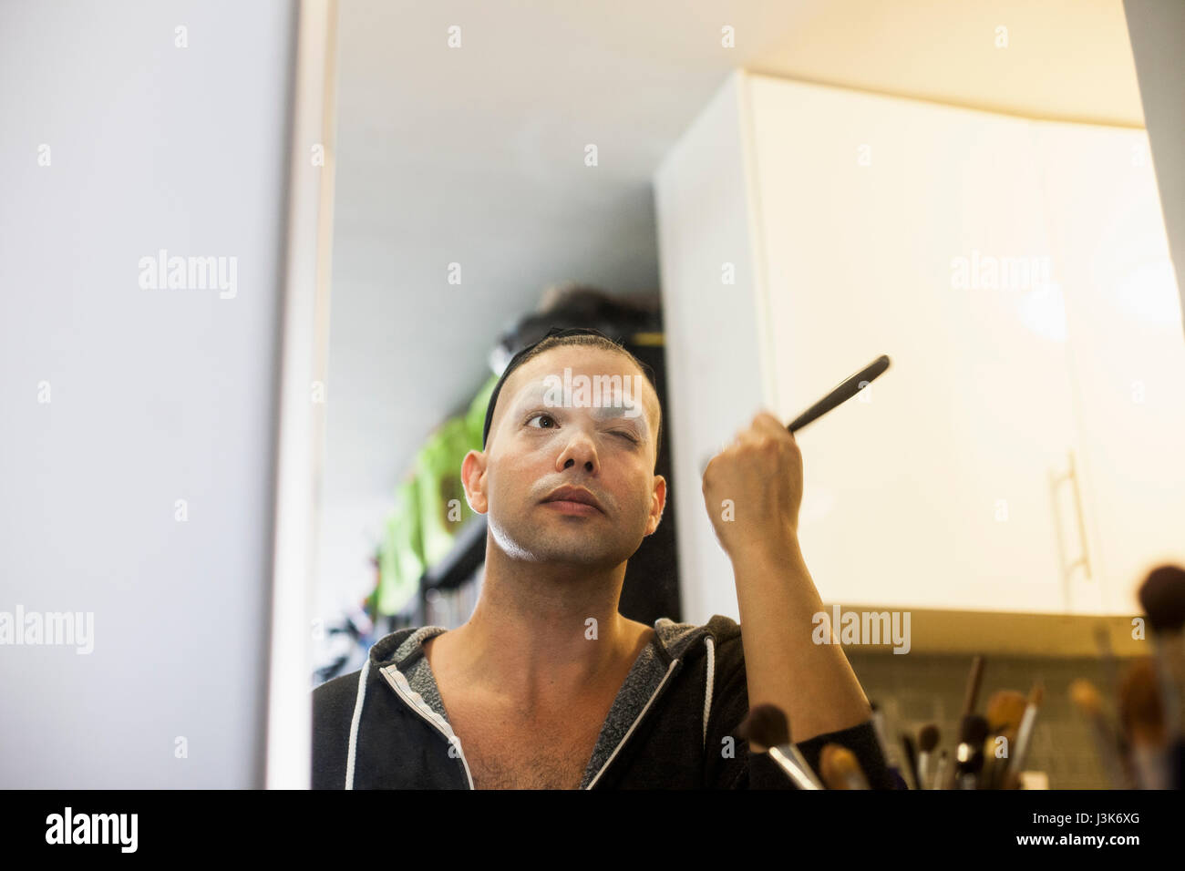 Giovane uomo applicazione trascina il trucco Foto Stock
