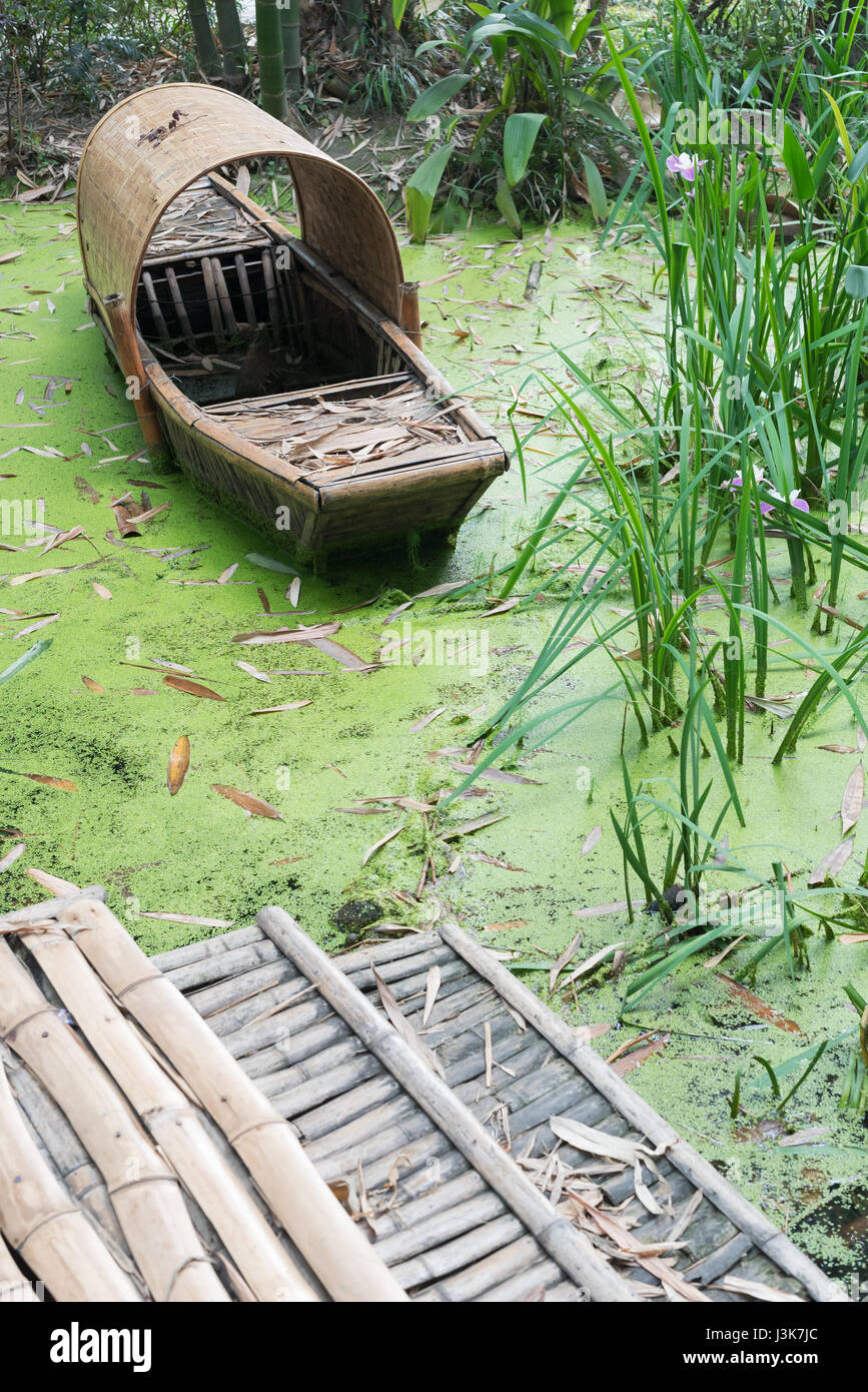 Abbandonato il cinese bamboo barca in acqua verde, Sichuan, in Cina Foto Stock