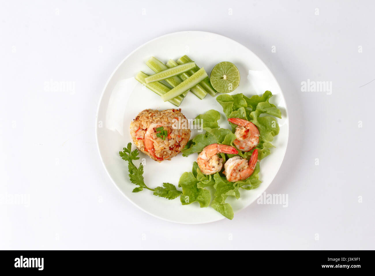 Riso fritto con gamberetti chiamata Khao Pad Kong in Thai è molto popolare in Asia cibo s di metà limone verde,cetriolo affettato e lattuga. Foto Stock