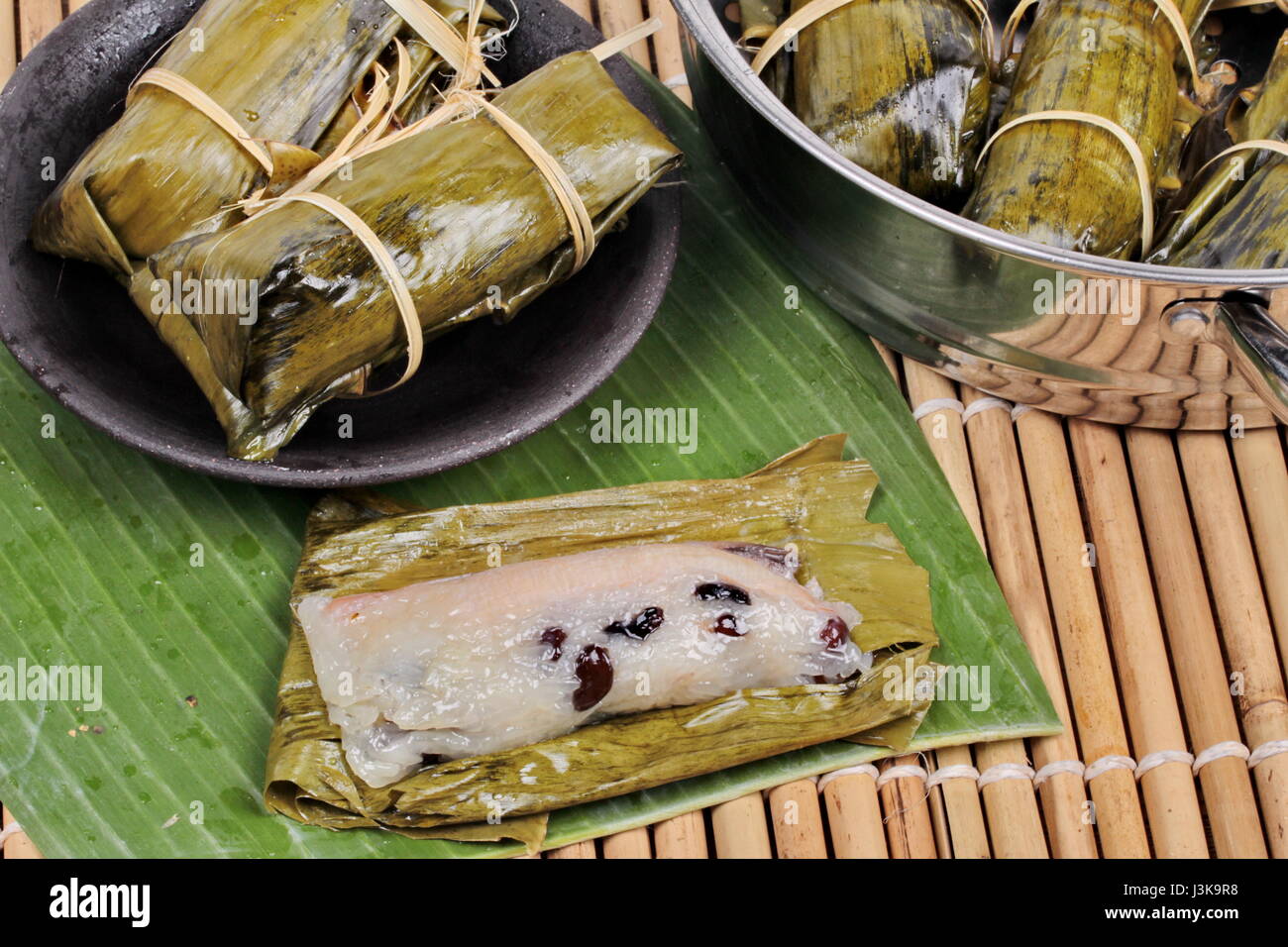 Popolari dessert Thai, in streaming di riso e fagioli neri in banana leaf chiamata Khao Tom Mad in thailandese servita sul piatto con cottura in pentola. Foto Stock